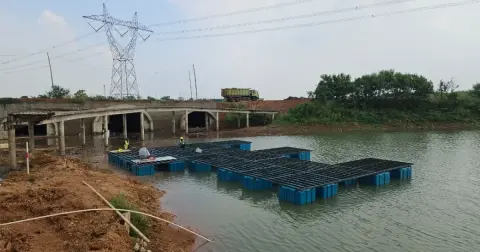 Rangkaian ponton biru membentuk tata letak dermaga di danau sebelum decking dipasang